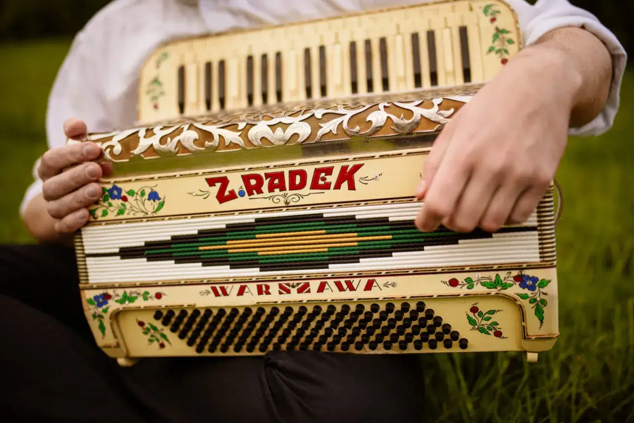 Osoba gra na akordeonie, pięknym instrumencie dętym klawiszowym z napisem 