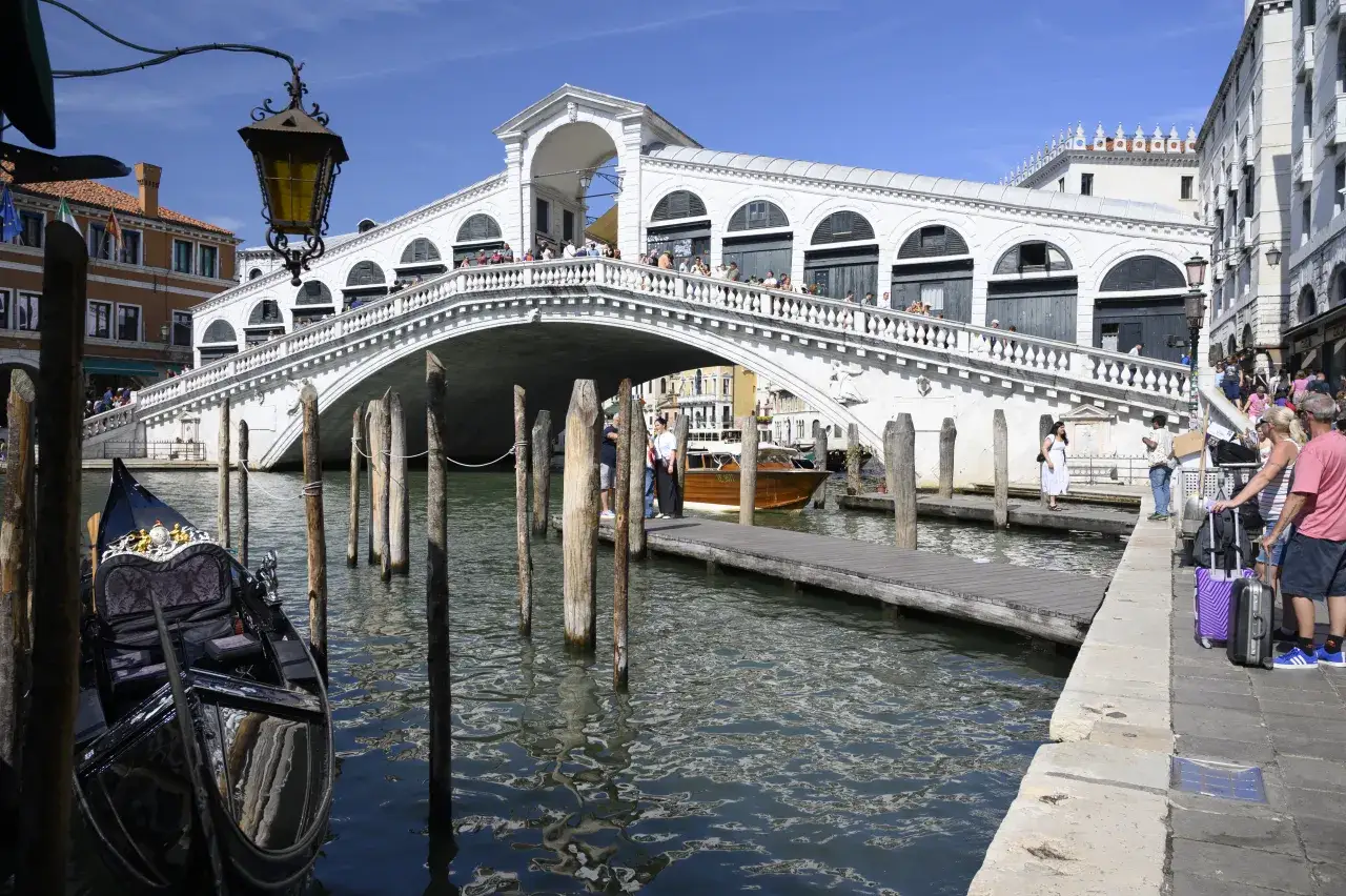 Most turystów na moście Rialto i gondola w kanale. Czy Wenecja jest bezpieczna? Tak, wygląda na to, że turyści czują się tu swobodnie.