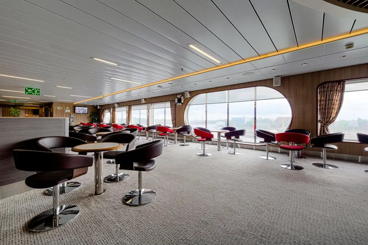 Wnętrze promu Nova Star z wygodnymi fotelami i stolikami, idealne na relaks podczas podróży.