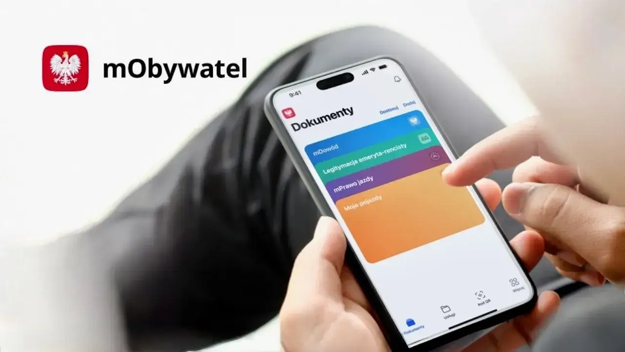 Dłoń z telefonem, na ekranie aplikacja mObywatel z opcją sprawdzenie prawa jazdy.