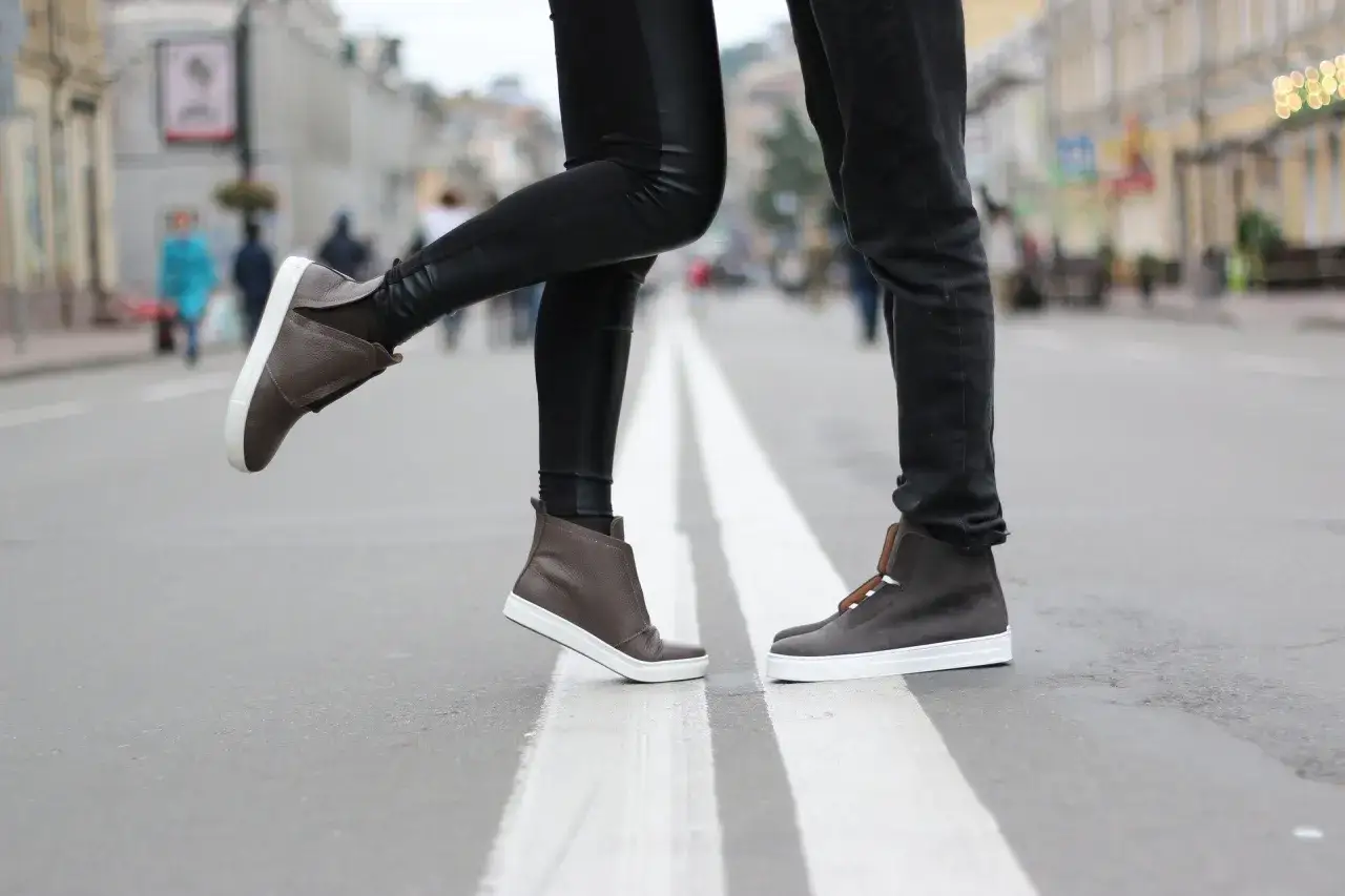 Para, gdy buty farbują od środka, co zrobić? Stylowe brązowe trampki na ulicy.