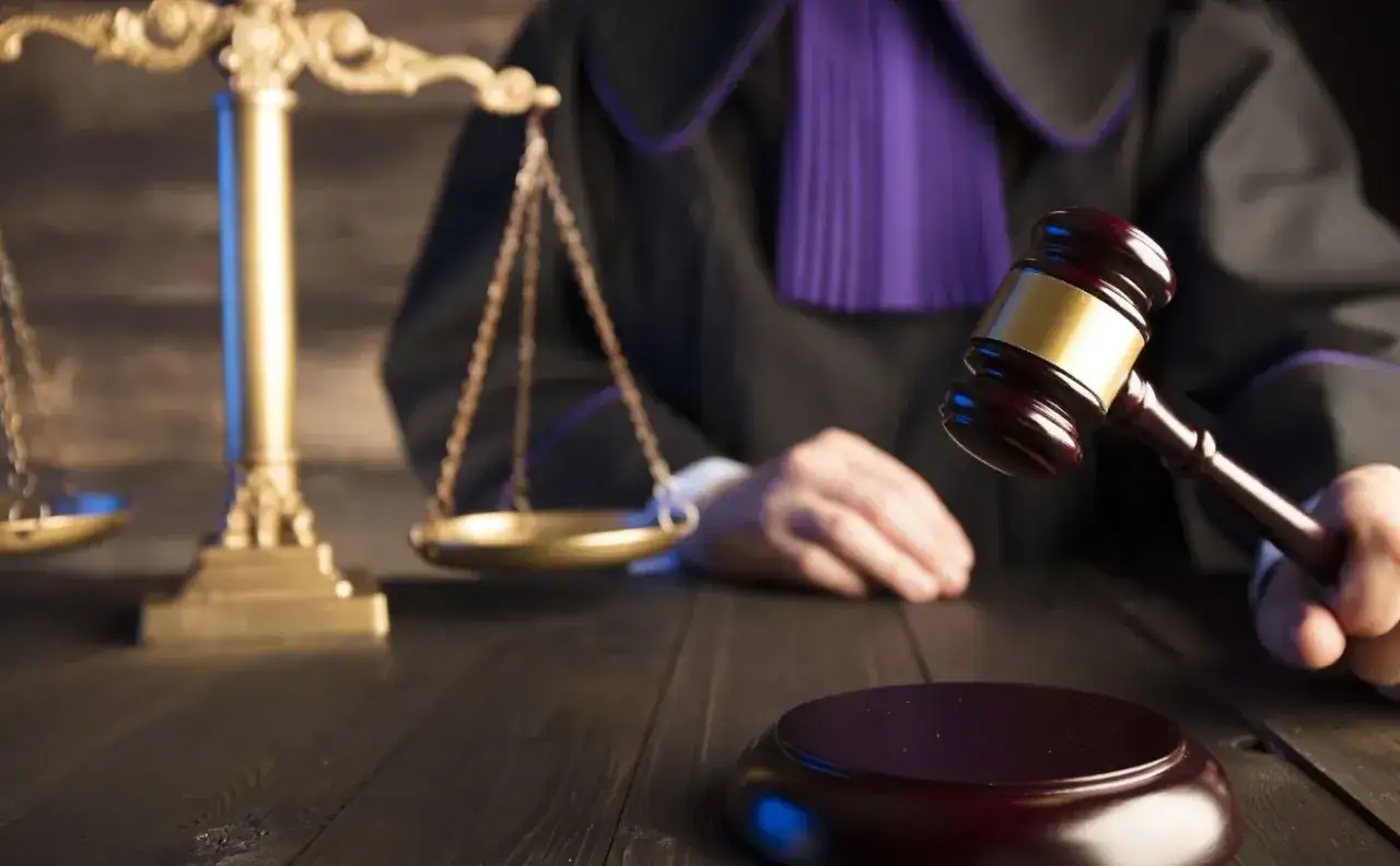 Sędzia w todze z młotkiem i wagą sprawiedliwości. Zastanawiasz się, ile czasu ma sąd na odpowiedź?