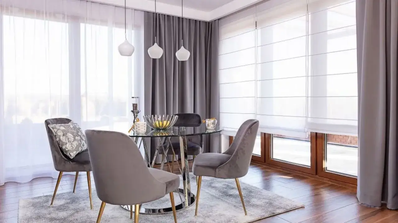 Eleganckie firany w salonie tworzą przytulną atmosferę wokół szklanego stołu i aksamitnych krzeseł.