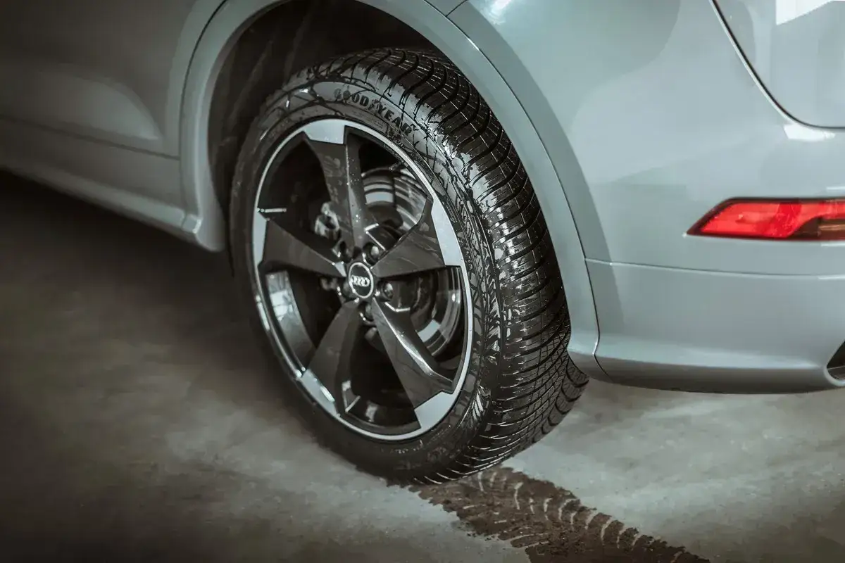 Zastanawiasz się, jakie opony zimowe wybrać? Na zdjęciu widać mokrą oponę Goodyear na feldze Audi, gotową na śnieg.
