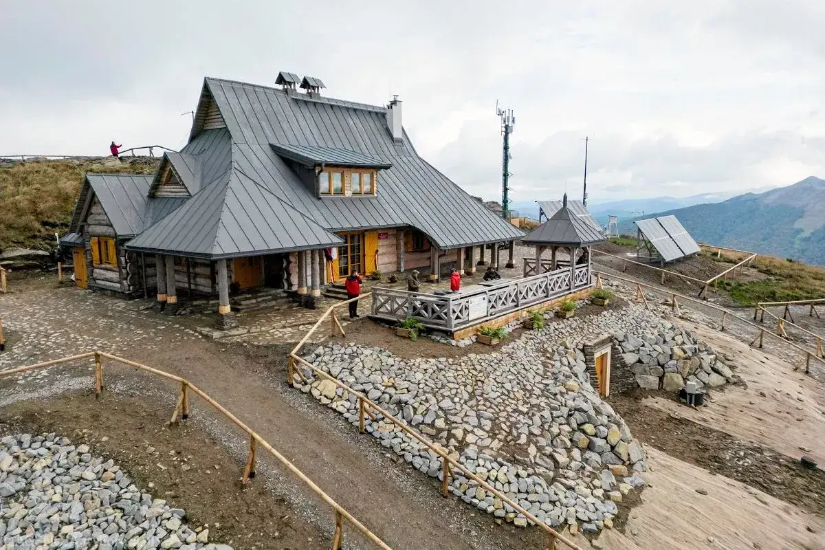 Drewniana chatka Puchatka w Bieszczadach, z tarasem i widokiem na góry.