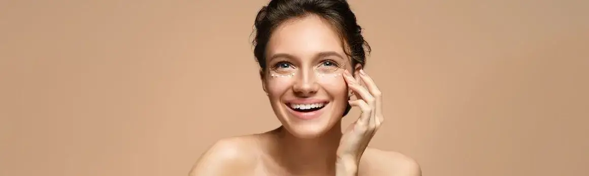 kobieta nakładająca krem pod oczy, pielęgnacja skóry pod oczami