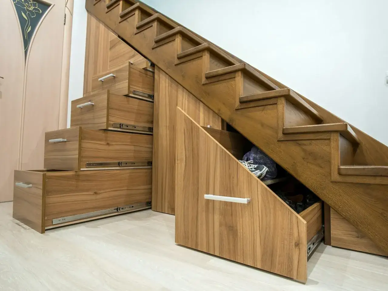Wnęka pod schodami z szufladami to świetne pomysły na przechowywanie but&oacute;w i innych drobiazg&oacute;w.
