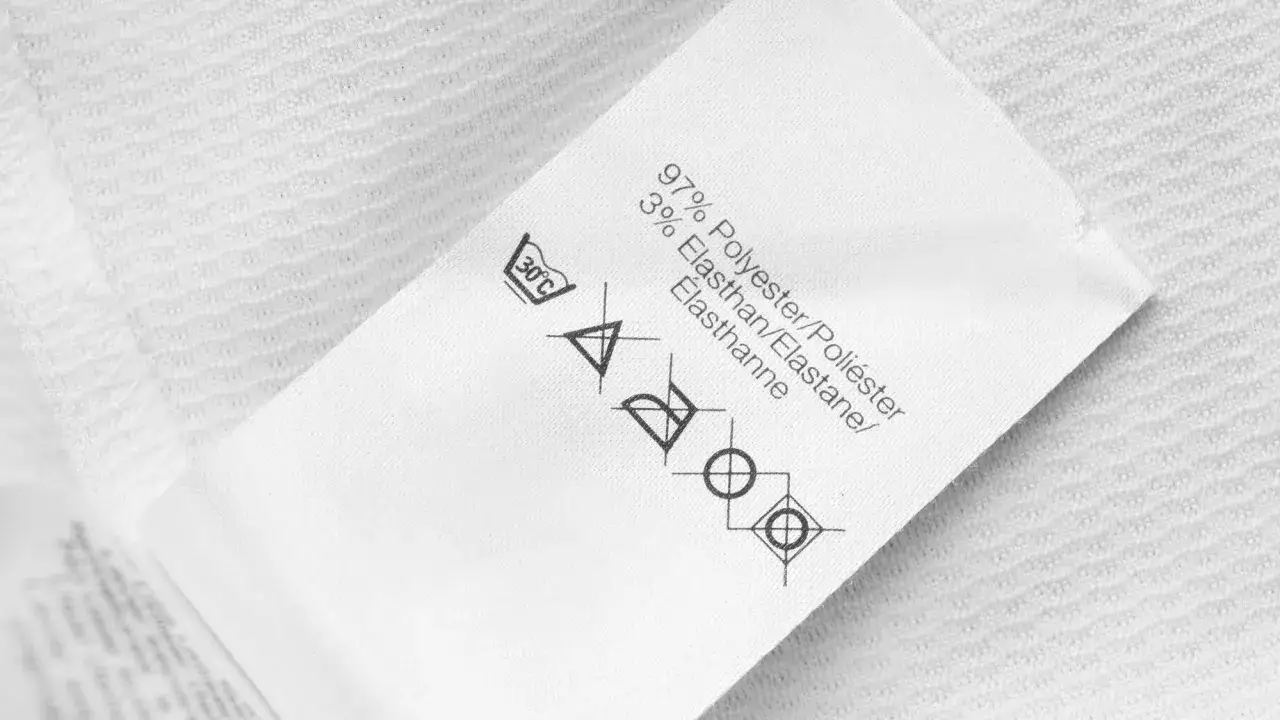 Metka z instrukcją prania: 97% poliester, 3% elastan. Symbol prania chemicznego wskazuje, że produkt jest przeznaczony do czyszczenia na sucho.