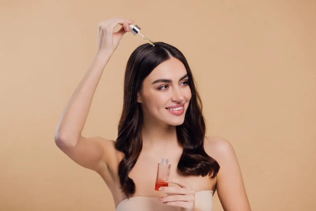 kobieta aplikująca wcierkę do włosów