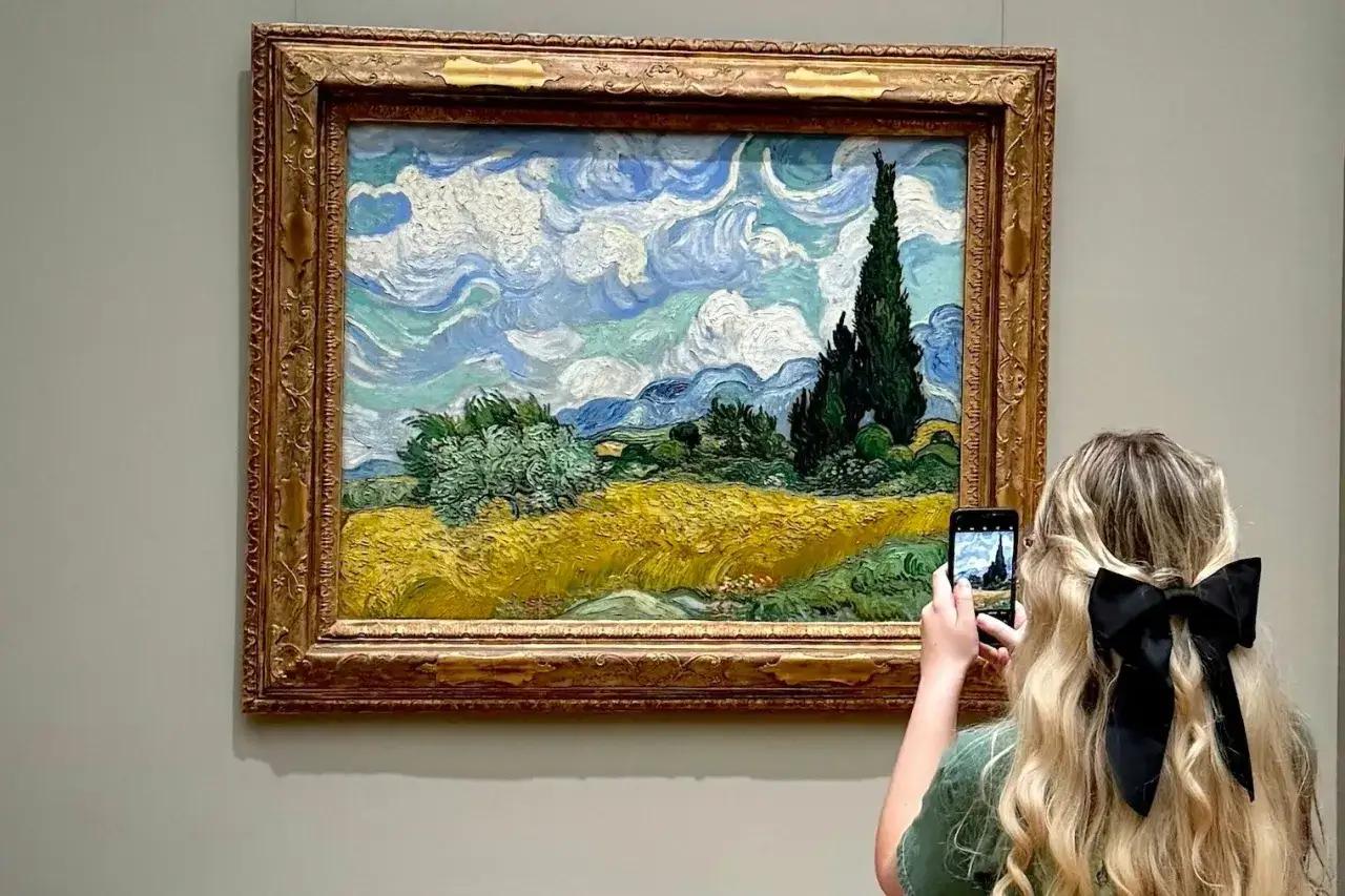 Dziewczyna z czarną kokardą we włosach robi zdjęcie obrazu Van Gogha 