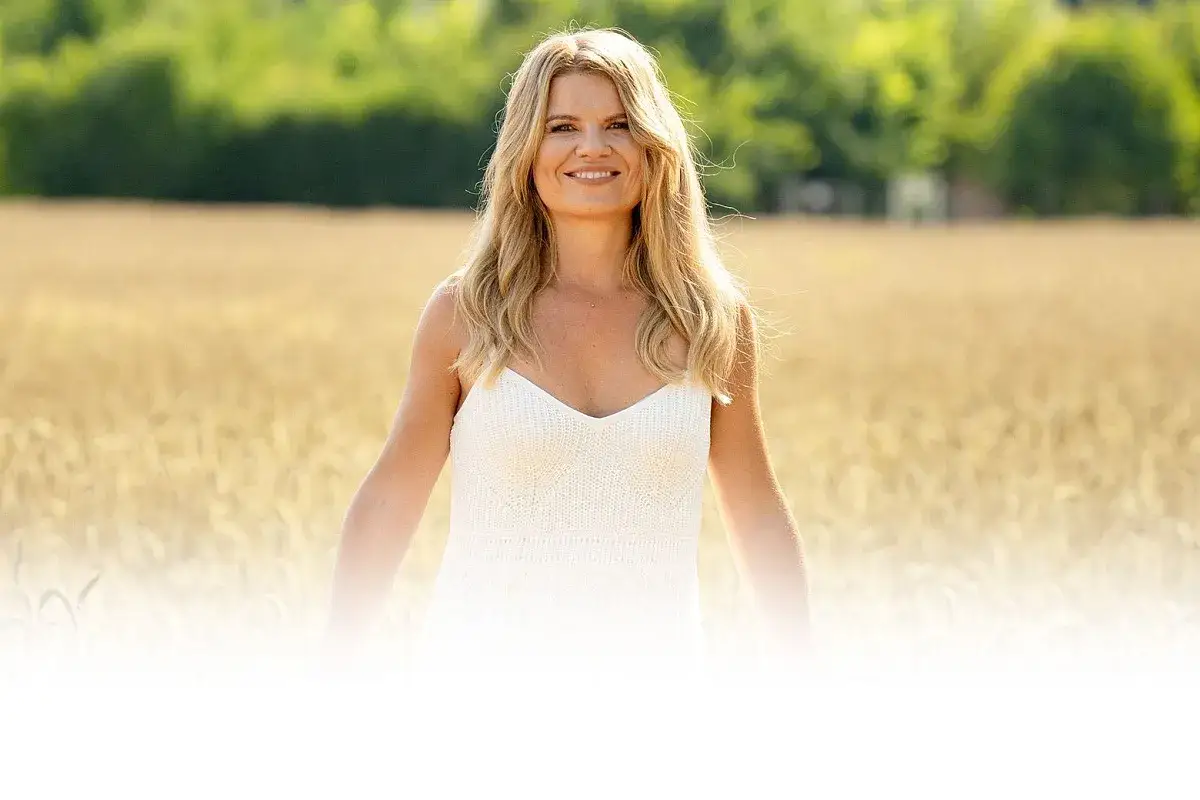 Uśmiechnięta blondynka w białej sukience na tle złotego pola pszenicy. Czyżby powtórka