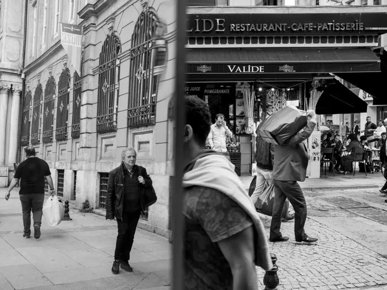 Ulica, ludzie w ruchu, sklep z szyldem 