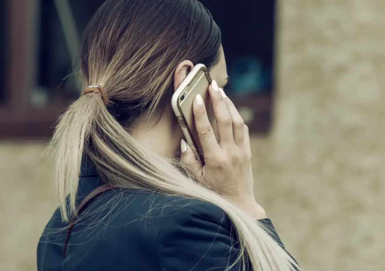 Kobieta rozmawia przez telefon, martwiąc się, czy pracodawca może odmówić urlopu.