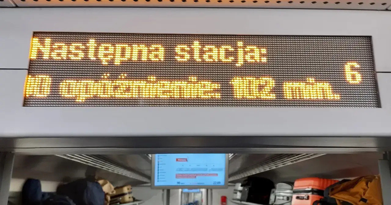 pasażerowie otrzymujący posiłki na stacji podczas op&oacute;źnienia pociągu