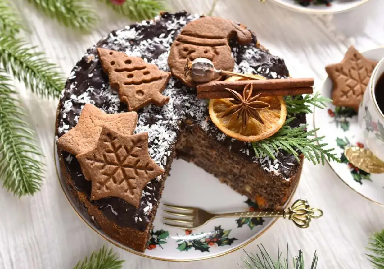 Wilgotny makowiec z gotowej masy makowej, udekorowany pierniczkami, pomarańczą i cynamonem, wygląda jak świąteczny przysmak.