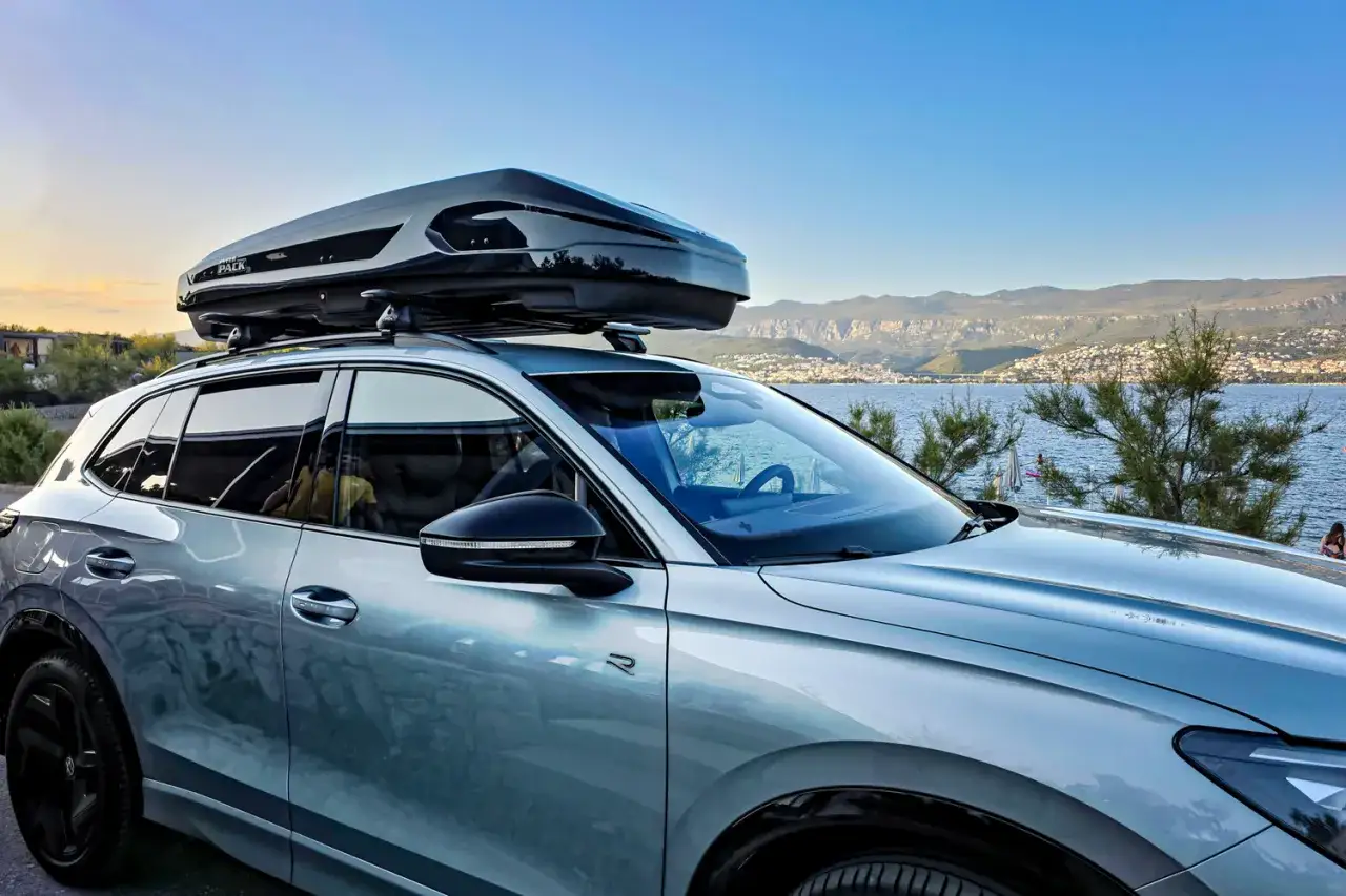 Srebrny SUV z boxem dachowym na narty gotowy na zimową wyprawę nad morze.