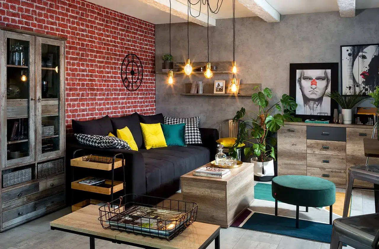 Męski pok&oacute;j inspiracje: loftowy salon z ceglaną ścianą, czarną kanapą, drewnianymi meblami i industrialnymi lampami.