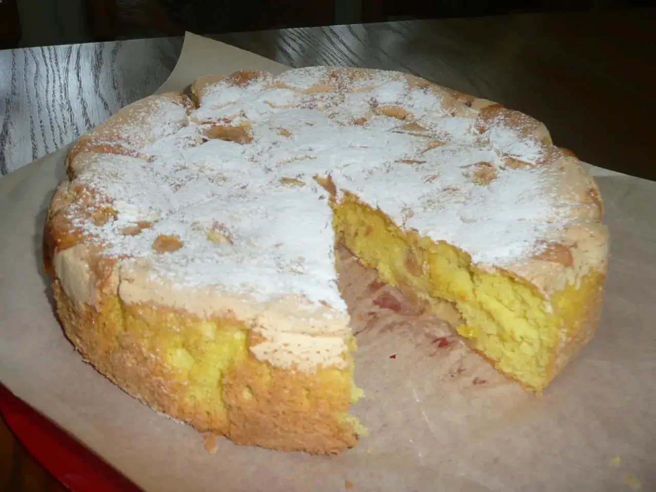 Puszysty biszkopt z jabłkami, posypany cukrem pudrem, czeka na spr&oacute;bowanie. Idealny na deser.