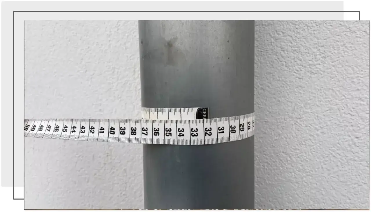 Miarka krawiecka owinięta wokół rury pokazuje obwód. Aby obliczyć średnicę rury, zmierz obwód i podziel przez π (około 3,14).