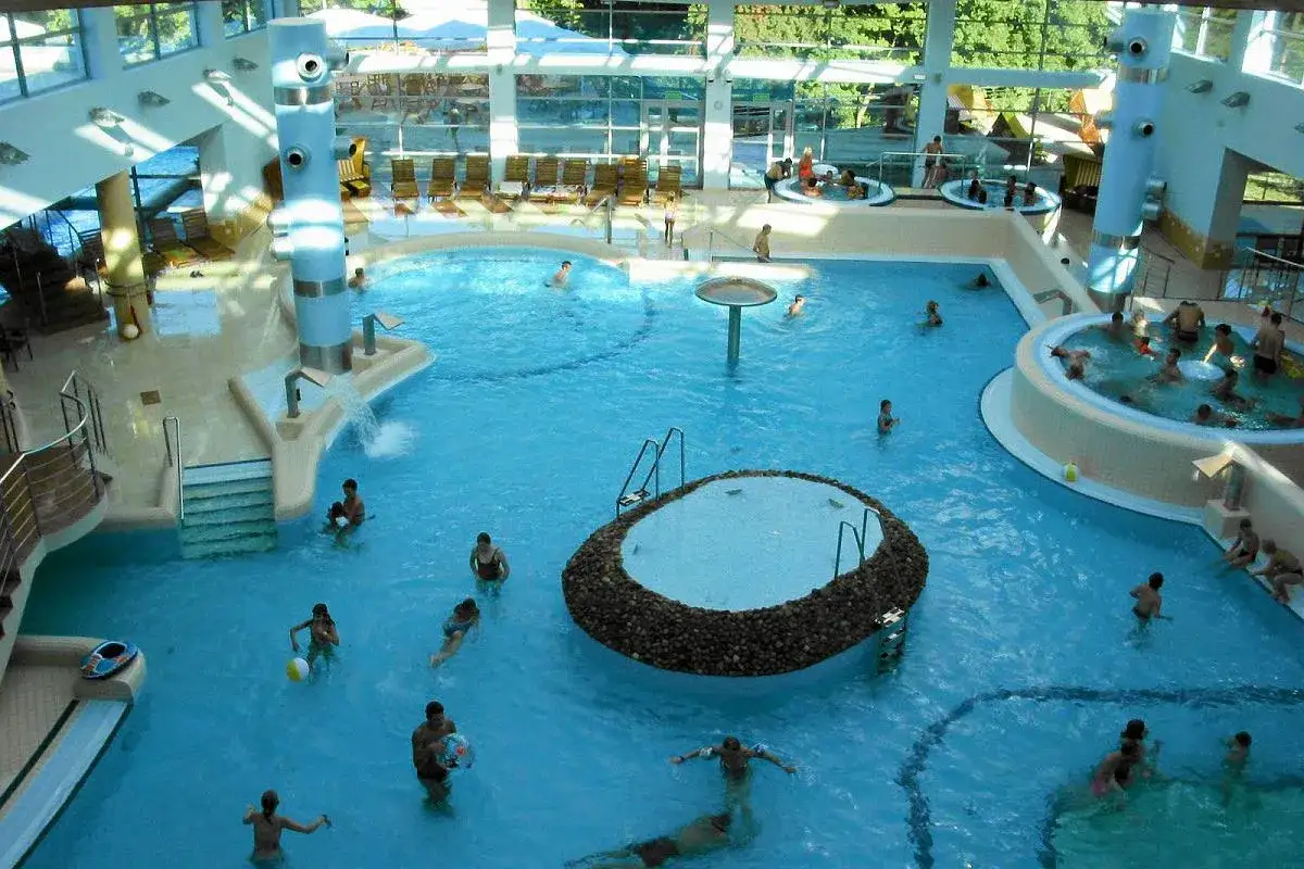 Wesołe rodzinne popołudnie w aquaparku w Sopocie. Wiele basenów, jacuzzi i ludzi cieszących się wodą.