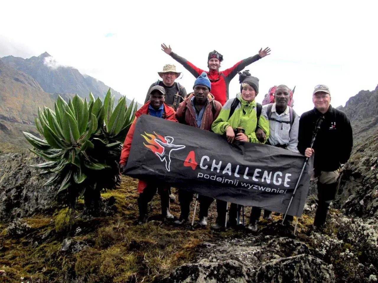 Grupa zdobywców na tle gór księżycowych, trzymająca baner 