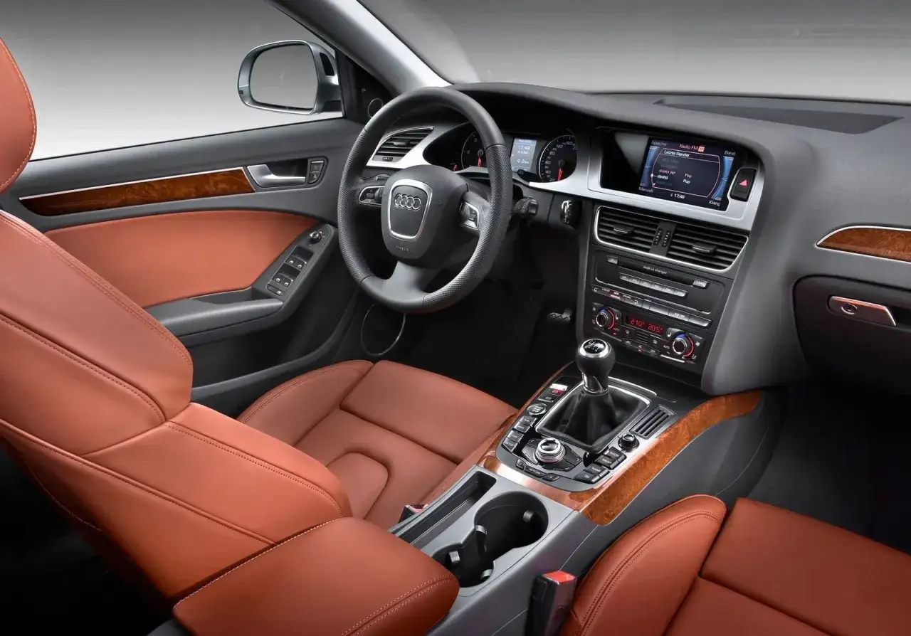 Wnętrze Audi A4 B8 z brązową skórzaną tapicerką. Typowe usterki tego modelu mogą dotyczyć elektroniki lub układu napędowego.