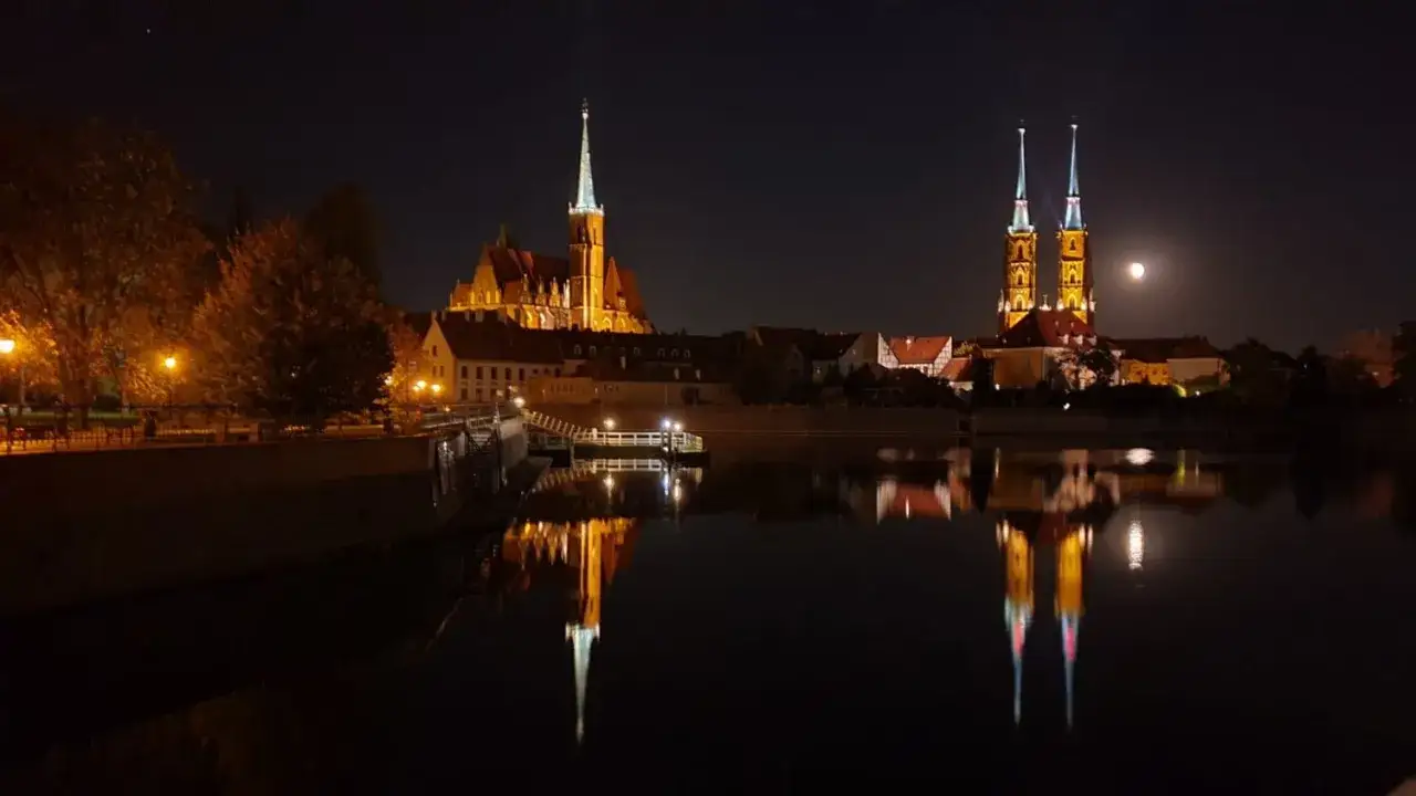 Nocny Wrocław z Ostr&oacute;wkiem i księżycem nad wieżami katedry. Idealne miejsce na romantyczny wiecz&oacute;r, odkryj wrocław atrakcje dla dorosłych.