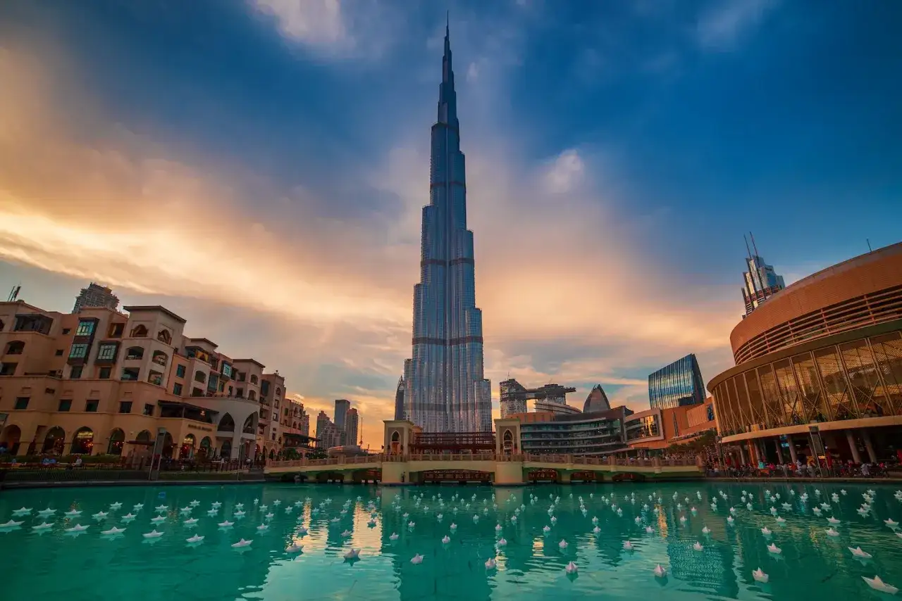 Burj Khalifa, najwyższy budynek świata, wznosi się nad wodami z tysiącami papierowych łódeczek podczas zachodu słońca.