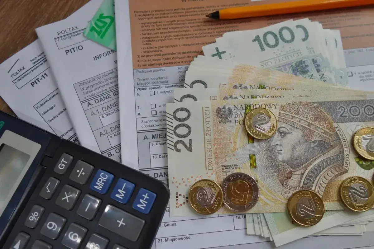 Kalkulator, polskie banknoty i monety na dokumentach podatkowych. Dowiedz się, jak odliczyć kredyt hipoteczny od podatku.