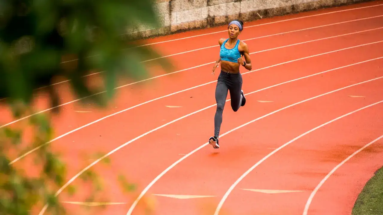 Kobieta biegnie po bieżni, dążąc do maksymalnego VO2 max.