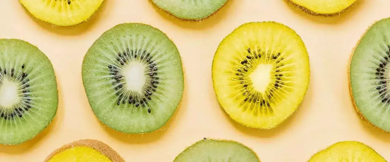 Zielone i ż&oacute;łte kiwi pokrojone w plastry, z widocznymi nasionami. Czy kiwi jest zdrowe? Tak, to pyszny owoc pełen witamin!