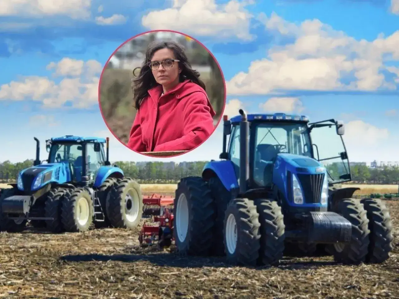 Kobieta w okularach i czerwonym płaszczu na tle nieba i dwóch niebieskich traktorów. Temat: emerytura z KRUS a dopłaty bezpośrednie.