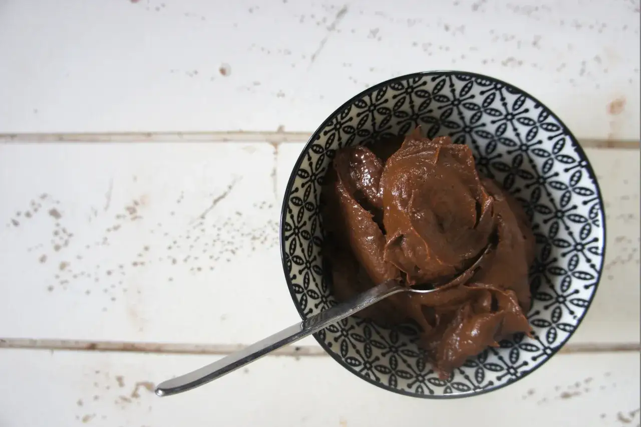 Miska z kremem czekoladowym, kt&oacute;ry wygląda jak Nutella. Czy nutella jest wegańska? To pytanie nurtuje wielu.