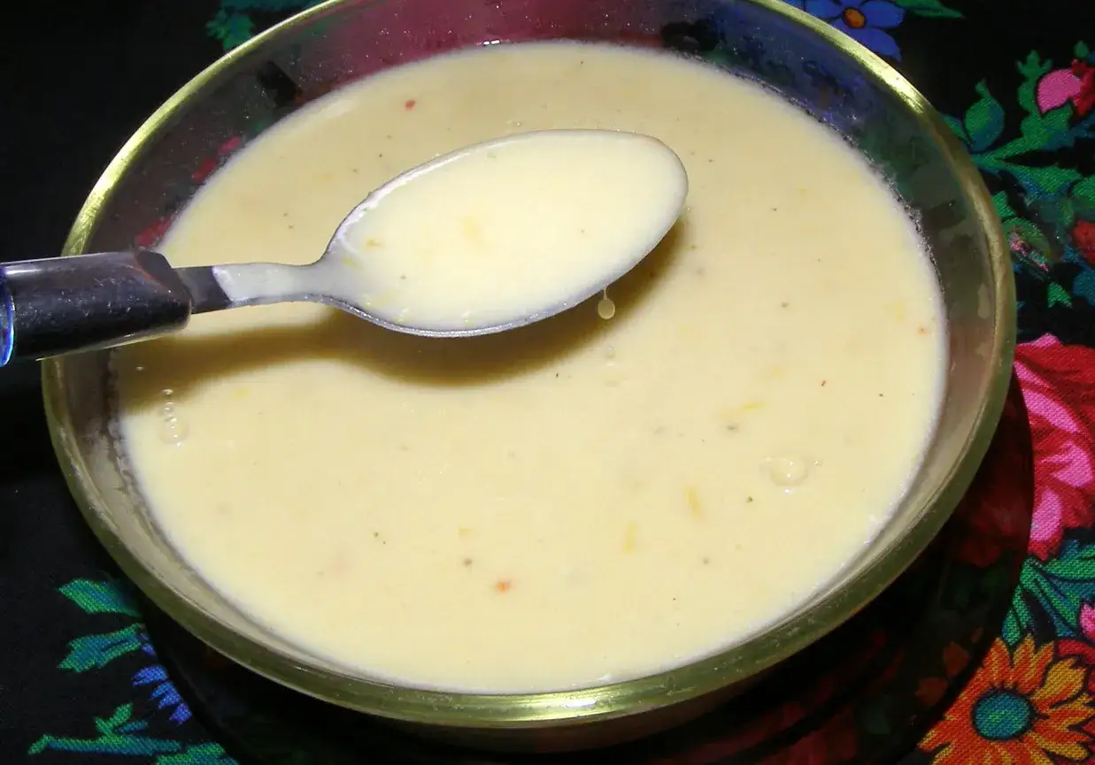 Kremowy sos cytrynowy do ryby, z łyżką zanurzoną w misce. Idealny dodatek do delikatnego fileta.