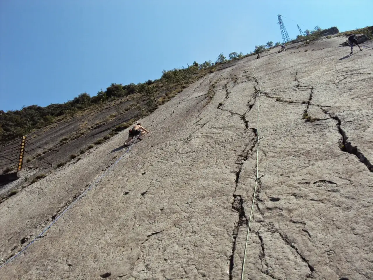 Pokonywanie objawów lęku wysokości na szlaku. Wspinaczka po skalnej ścianie z użyciem łańcuchów, widoczni alpiniści.