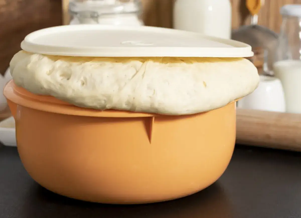 Wyrośnięte ciasto drożdżowe na suchych drożdżach w pomarańczowej misce. Idealne do wypieków, gdy szukasz sprawdzonego przepisu.