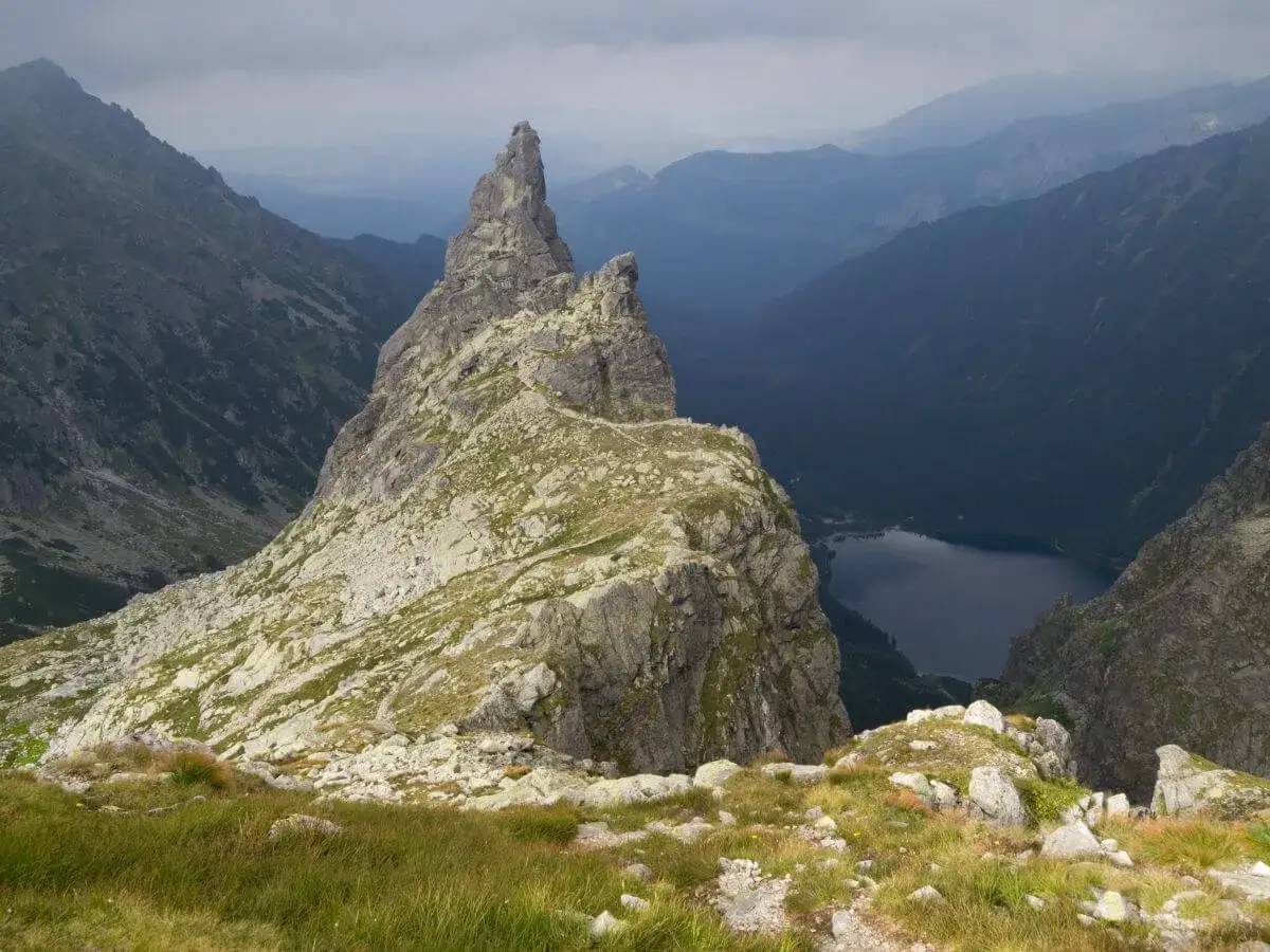 Majestatyczny Mnich Szczyt g&oacute;ruje nad doliną, gdzie w dole lśni ciemne jezioro.