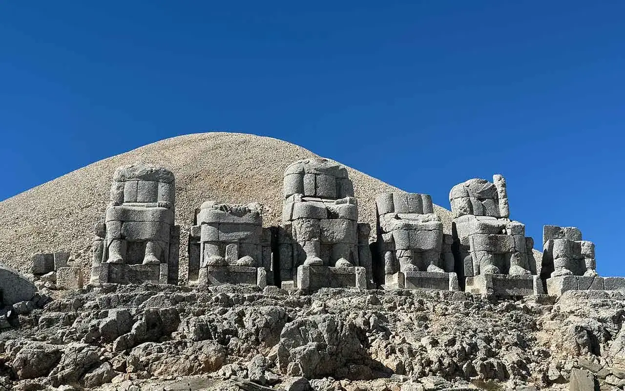 Kamienne posągi bog&oacute;w na g&oacute;rze Nemrut, strzegące starożytnego grobowca.