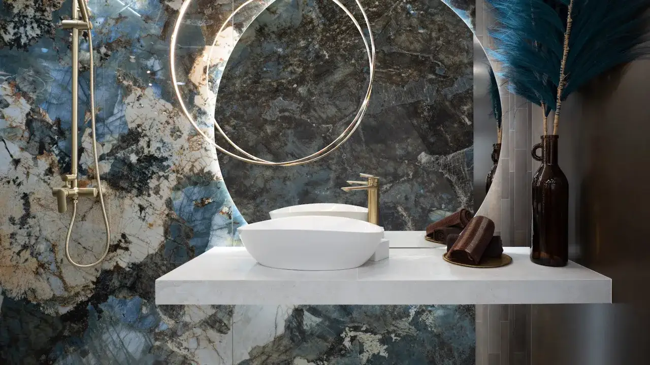 Nowoczesny blat pod umywalkę z płytek, z umywalką nablatową, złotą armaturą i ozdobną butelką z gałązkami.