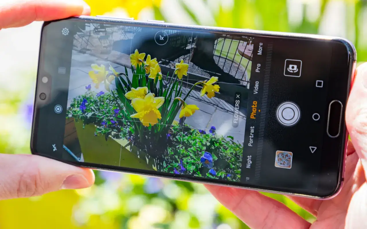 Kwiaty uchwycone przez aparat Huawei P20 Pro. Ż&oacute;łte narcyzy i fioletowe bratki w donicy.