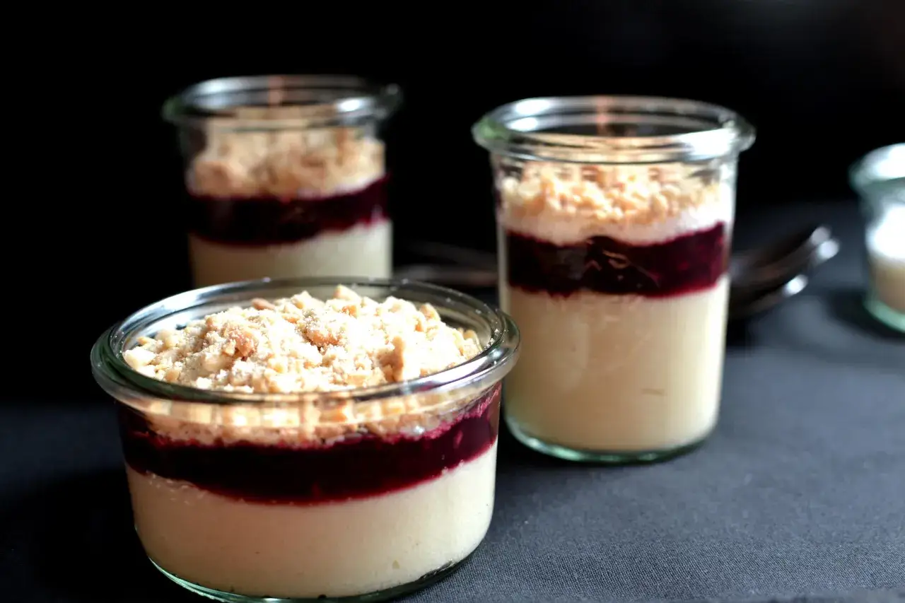 Pyszne desery z ugotowanej kaszy manny z musem owocowym i kruszonką, podane w słoiczkach. Idealne na przekąskę.
