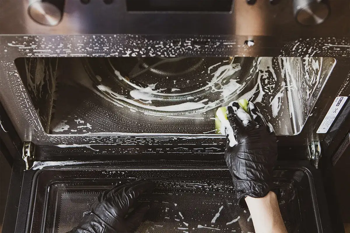 Rękawiczki i gąbka pomagają w walce z przypalonym tłuszczem w piekarniku. Czyszczenie piekarnika z tłuszczu staje się łatwiejsze.