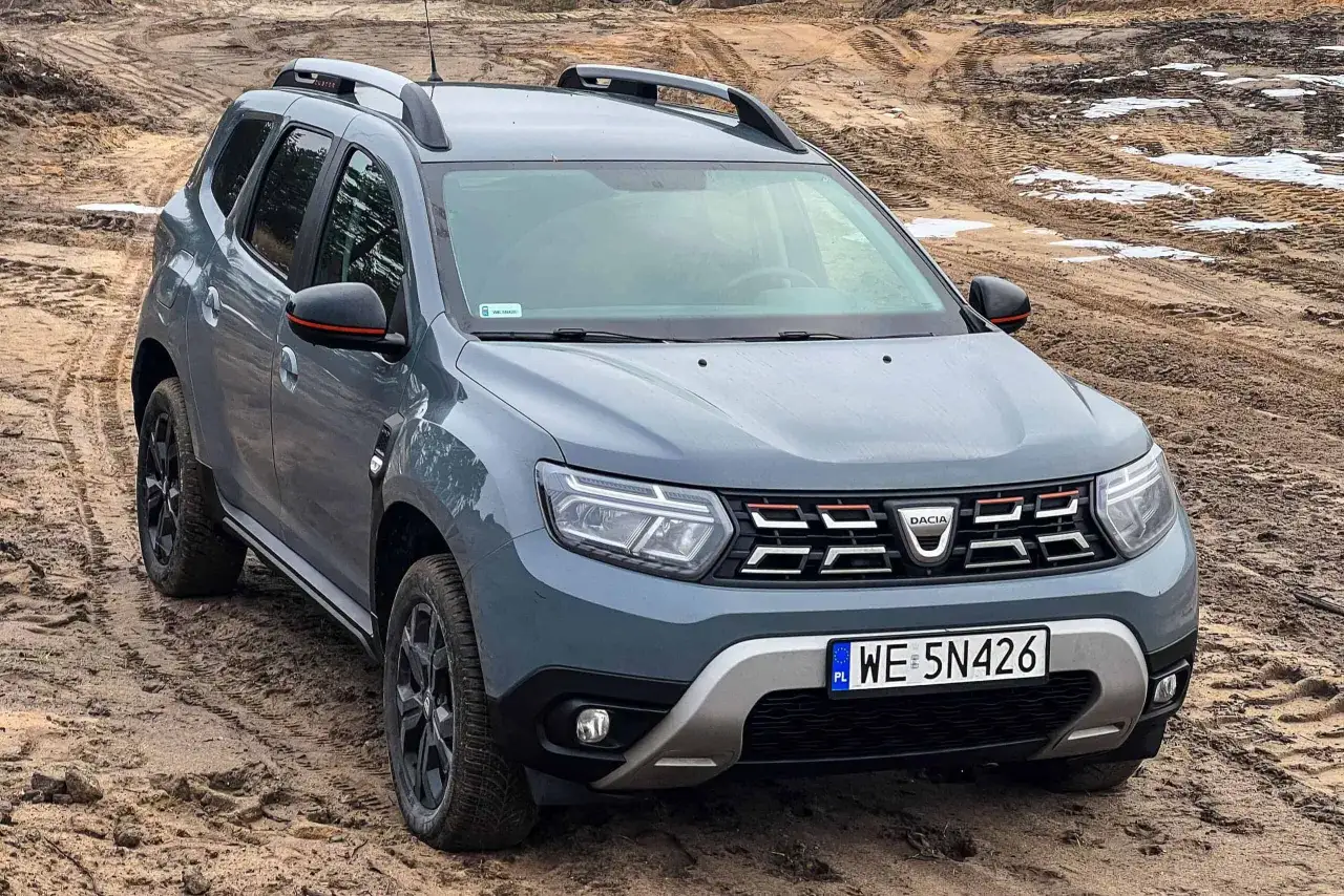 Szary Dacia Duster na błotnistym terenie. Zastanawiasz się nad dacia duster spalanie?