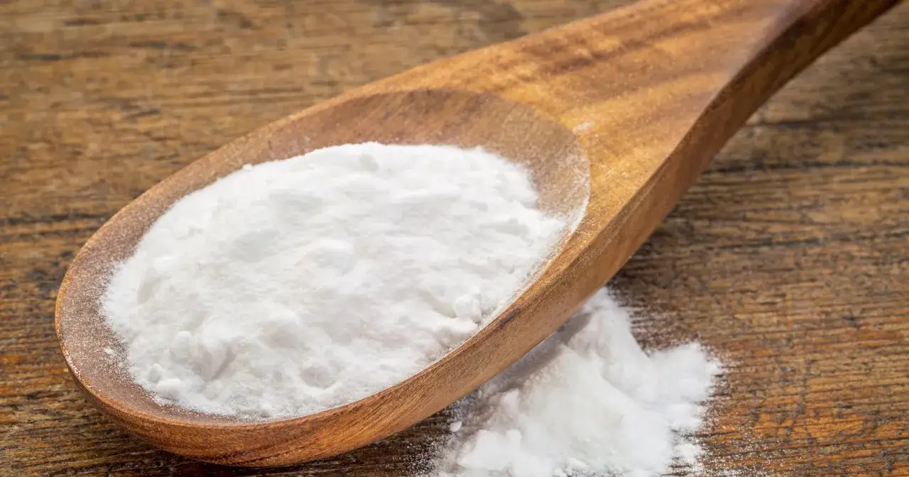 Łyżka z sodą oczyszczoną na drewnianym tle. Czy soda oczyszczona jest zdrowa? To pytanie nurtuje wiele os&oacute;b.