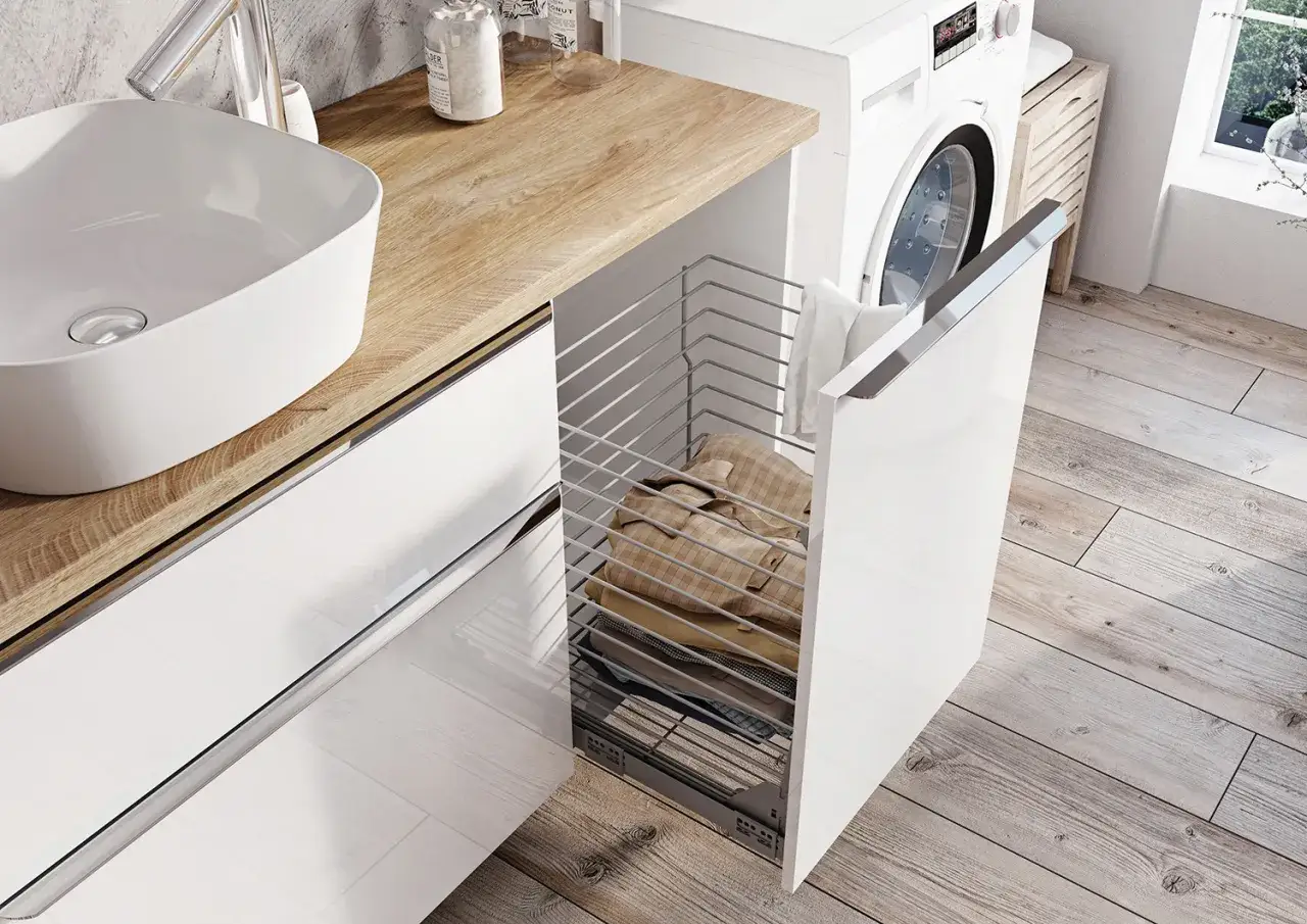 Nowoczesna łazienka 2m2 z pralką i wysuwanym koszem na pranie. Biała umywalka nablatowa, drewniany blat i błyszczące fronty szafek.