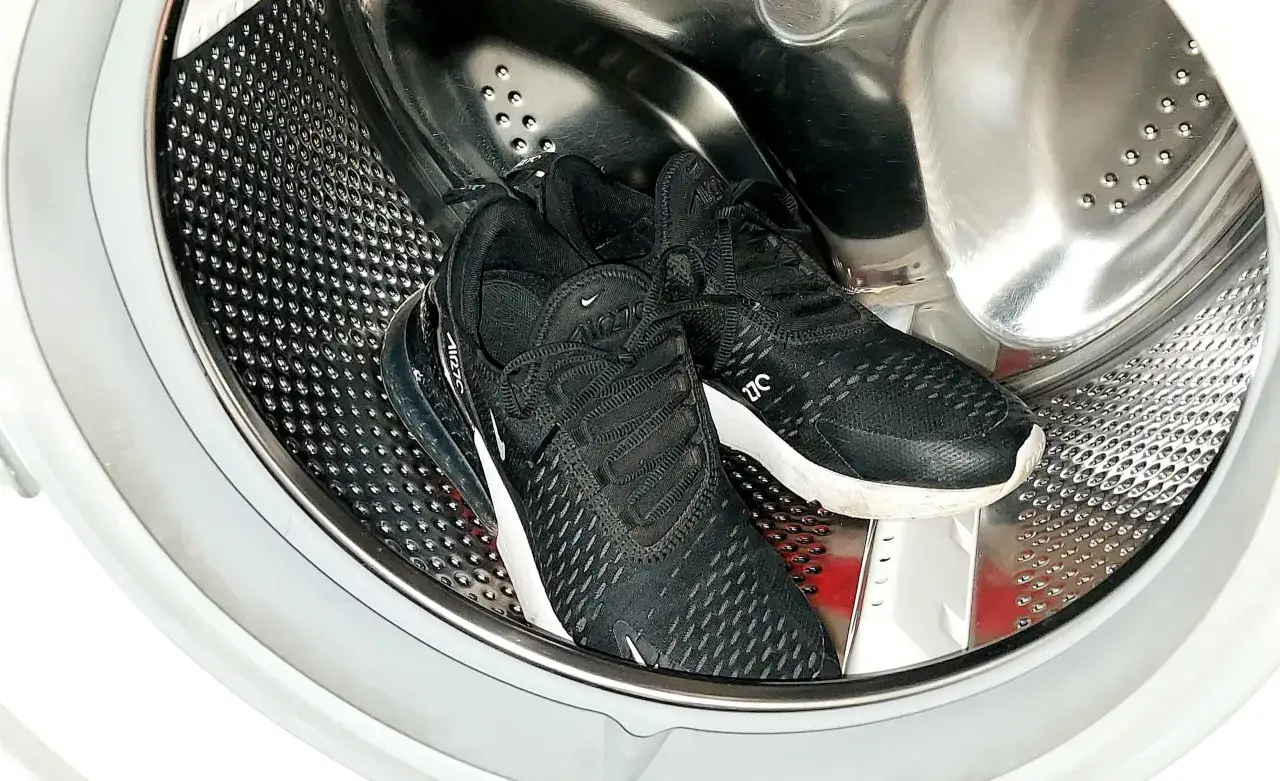Para prać conversy w pralce, umieść czarne buty sportowe w bębnie.