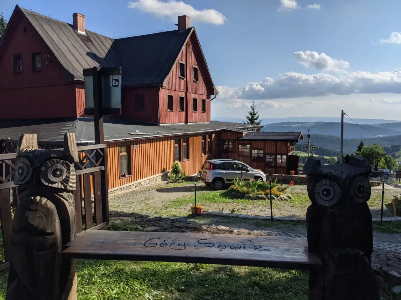Drewniane sowy strzegą ławki z napisem 