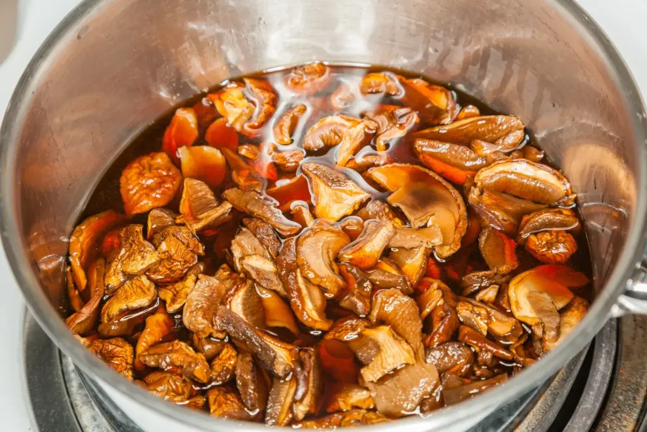 Suszone grzyby w garnku, gotowe do dalszego przygotowania. Dowiedz się, jak długo gotować suszone grzyby, by wydobyć ich pełnię smaku.
