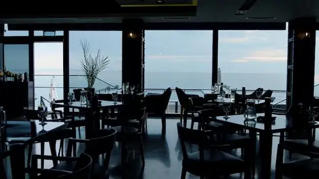 wnętrze przytulnej restauracji z widokiem na morze