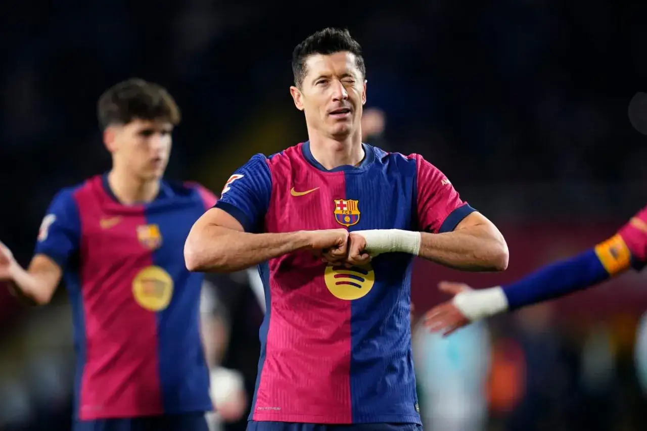 Robert Lewandowski w koszulce Barcelony, z bandażem na ręce, pokazuje gest. Czy to on poprowadzi drużynę do zwycięstwa w Lidze Mistrzów?